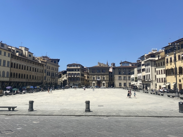       Wide plaza with historical buildings and people.
  