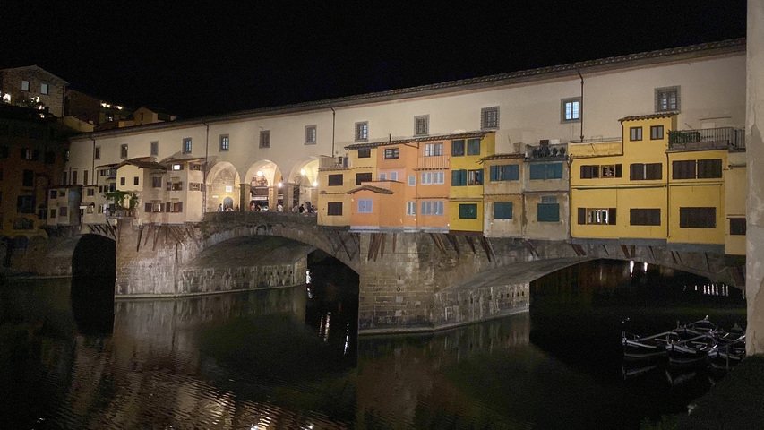       Night view of Ponte Vecchio over a river.
  