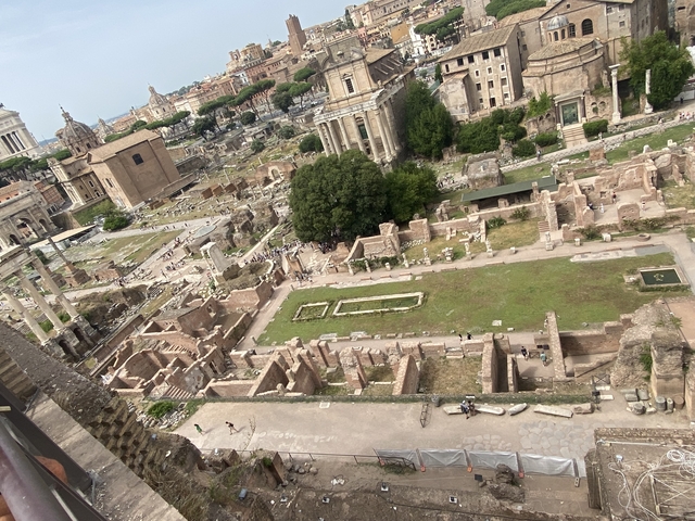 Ancient ruins with city skyline in background.