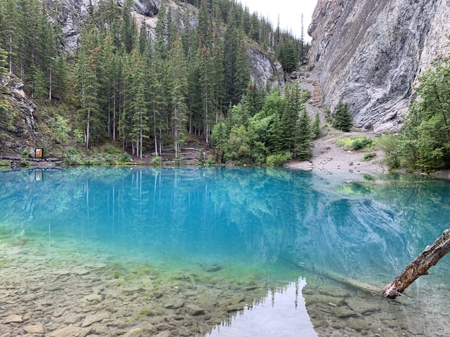       A lake surrounded by rocky cliffs and dense forests.
  