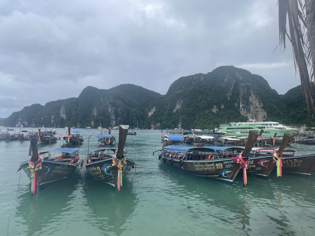 Boats anchored in a bay with steep hills in the background.