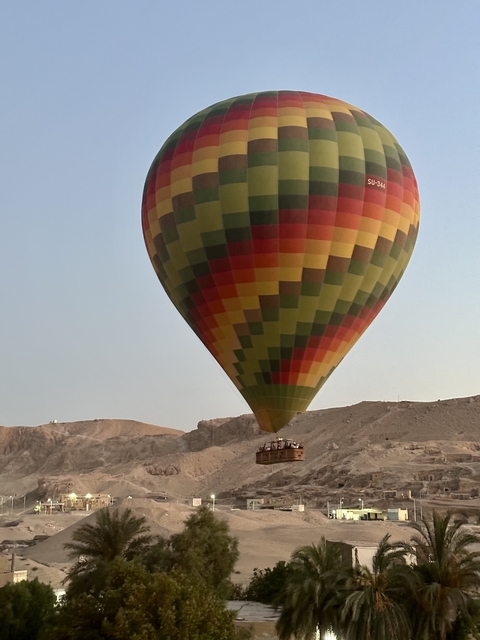       A hot air balloon taking off against a desert backdrop.
  
