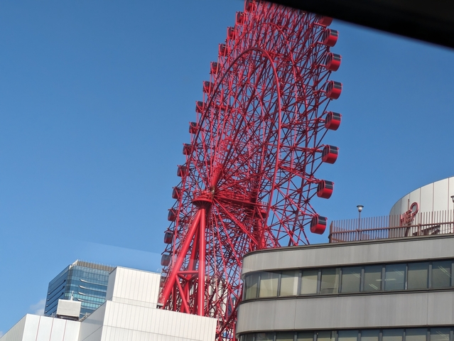       Red Ferris wheel against a clear blue sky.
  