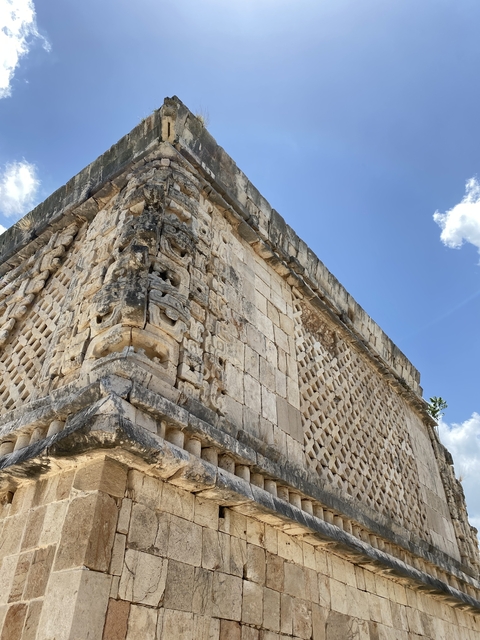 Close-up of a detailed stone building with intricate carvings under a blue sky.
