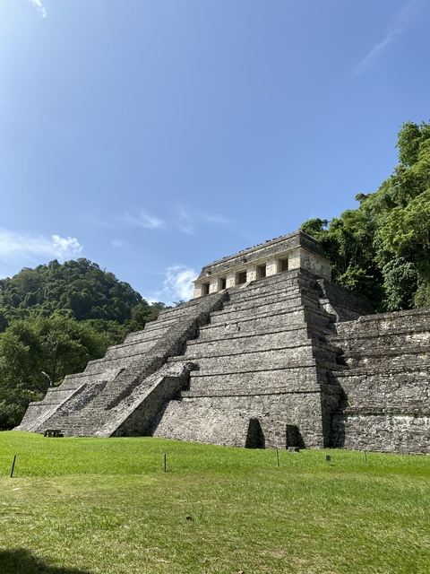       Stone pyramid structure in a forested area.
  