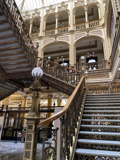 Ornate interior with a grand staircase and decorative lighting.