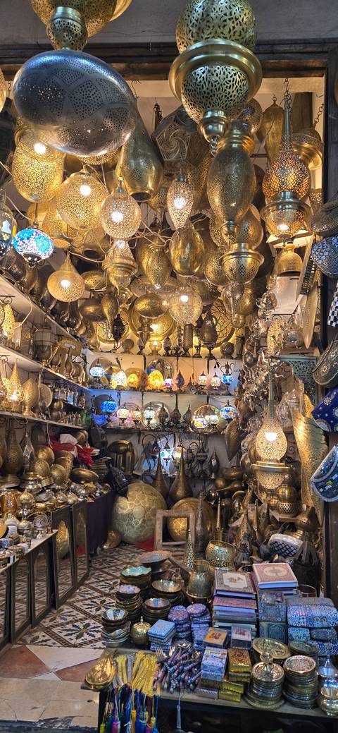 Shop filled with ornate metal lamps and decorations.