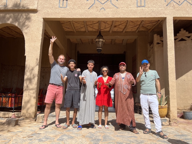       Group of people posing in front of a traditional building.
  