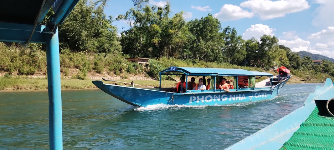 A boat labeled 'Phong Nha Cave' with passengers.