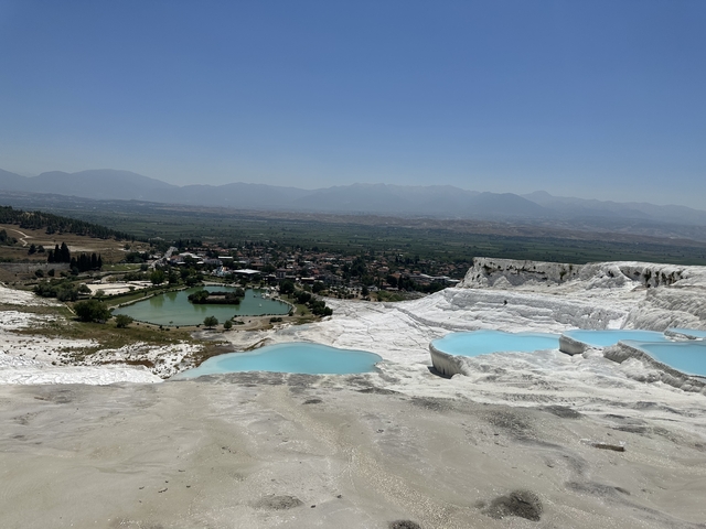 Natural white terraces with pools and a distant town.