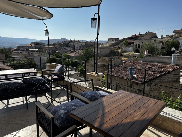       Outdoor patio with wooden tables and mountain views.
  