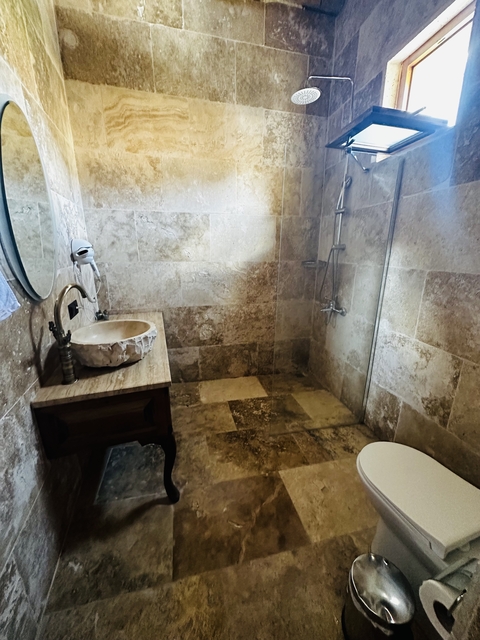Bathroom with stone tiles and a basic setup.