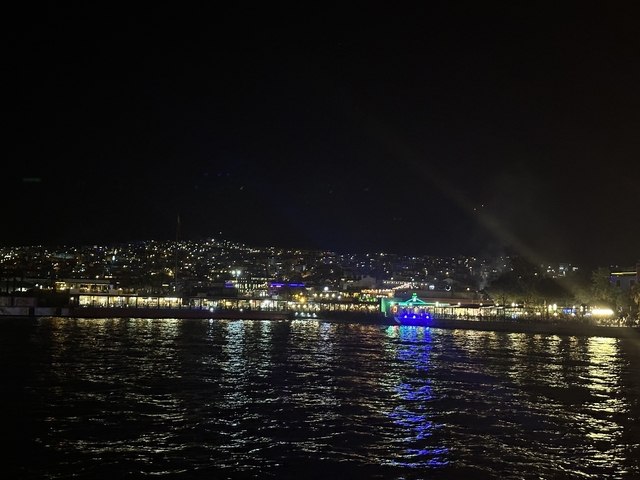 Night view of a city by the water with lights.