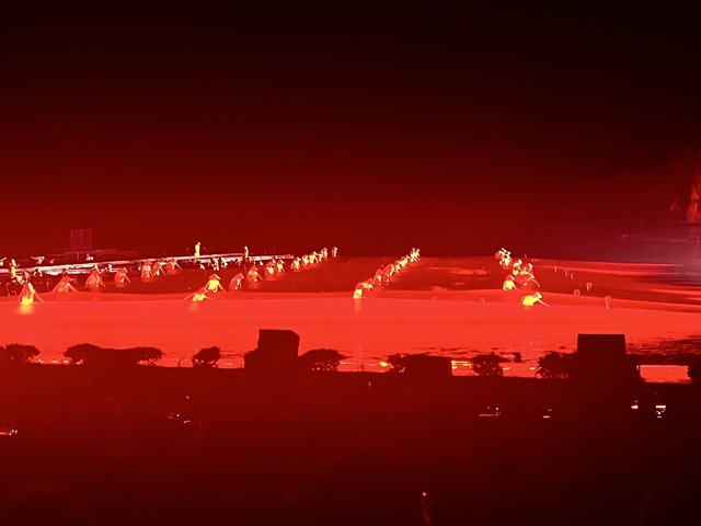 Night-time outdoor performance with dramatic red lighting.
