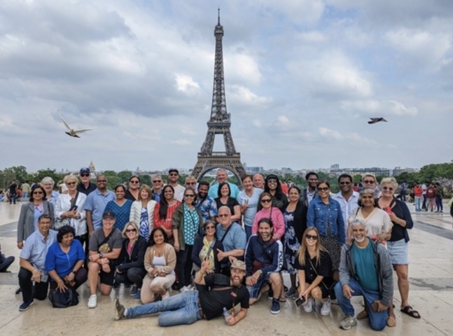 Large group photo in front of the Eiffel Tower.