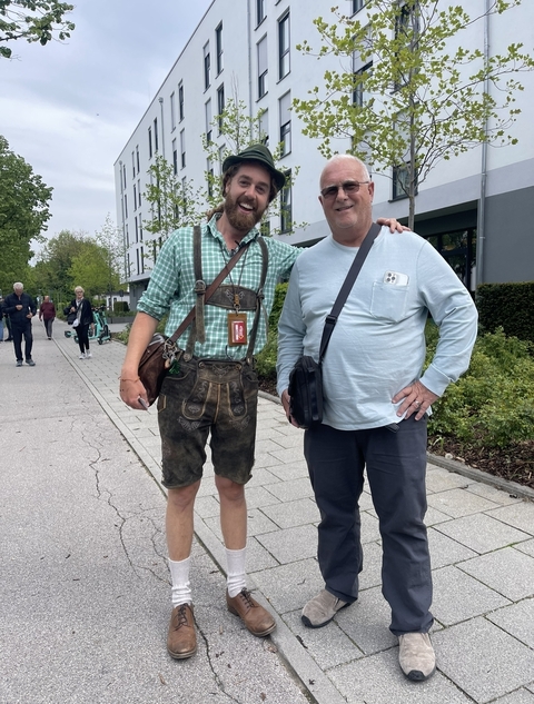 Two men standing outside in a casual city setting.