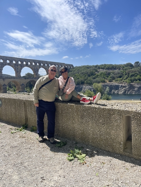 Couple posing by an ancient Roman aqueduct.