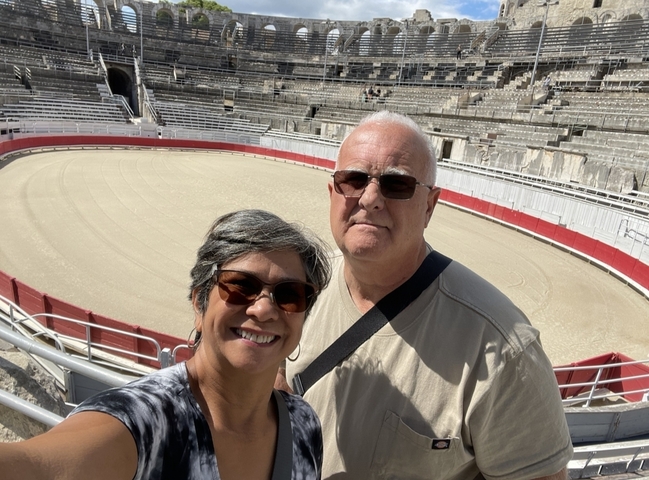 Couple posing inside a historical arena with empty seats.