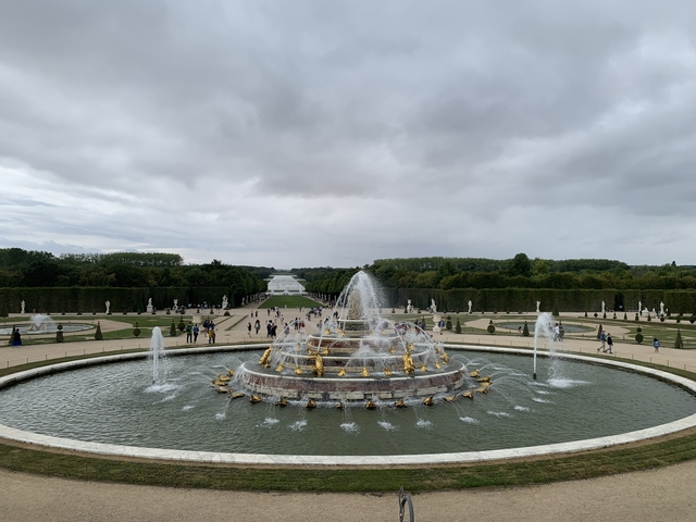       The large fountain with golden statues in a landscaped garden.
  