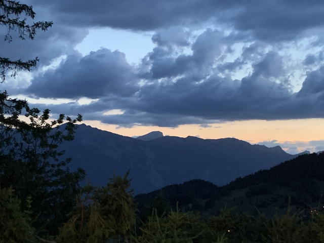       A silhouette of mountains during sunset.
  