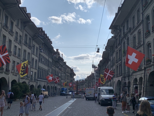       A street flanked by buildings decorated with Swiss flags.
  