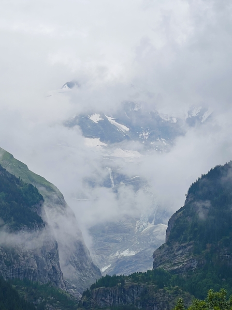 Snow-capped mountains partially obscured by clouds.