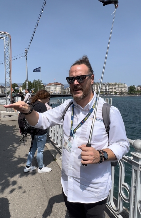 A tour guide speaking to a group near a lake.