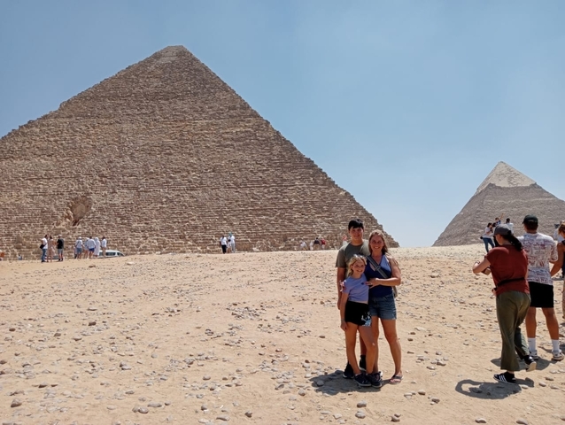 Family posing in front of the Pyramids.