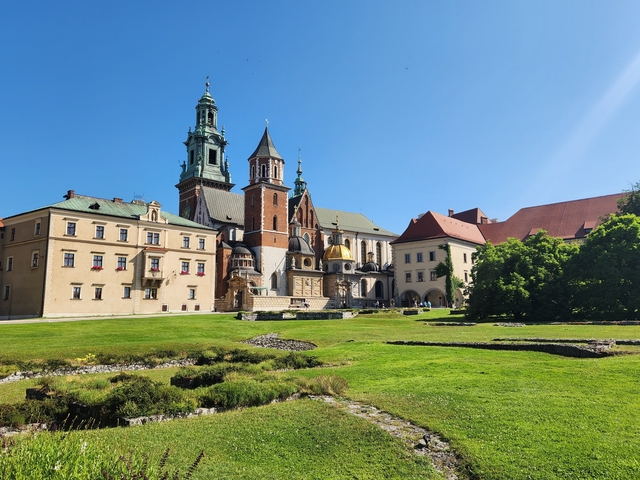       A historic castle-like building with grassy surroundings.
  