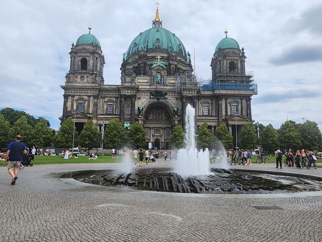       A large domed building with a fountain in the foreground.
  