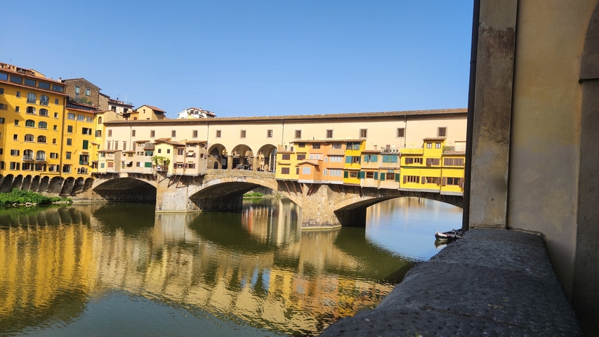       A historic bridge with buildings along the river.
  