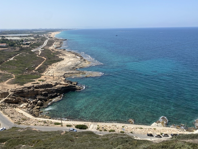       A scenic coastal view with cliffs and clear blue water.
  