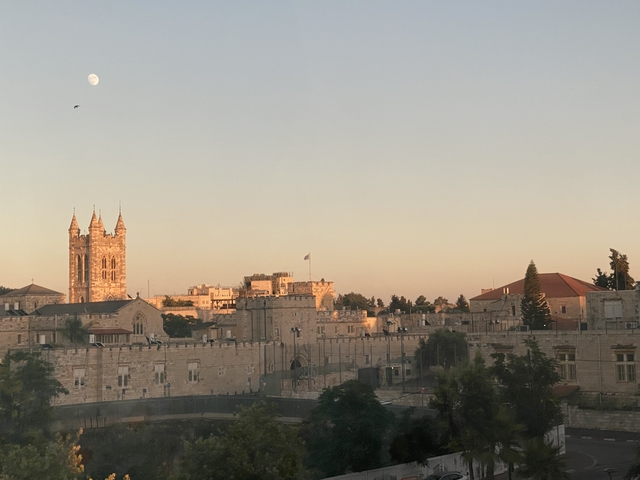       City landscape viewed at dusk with light on buildings.
  
