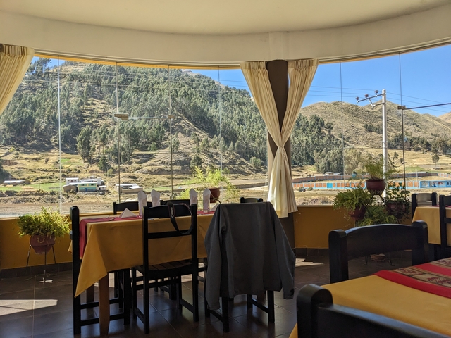       Interior of a restaurant with a view of mountains through the windows.
  