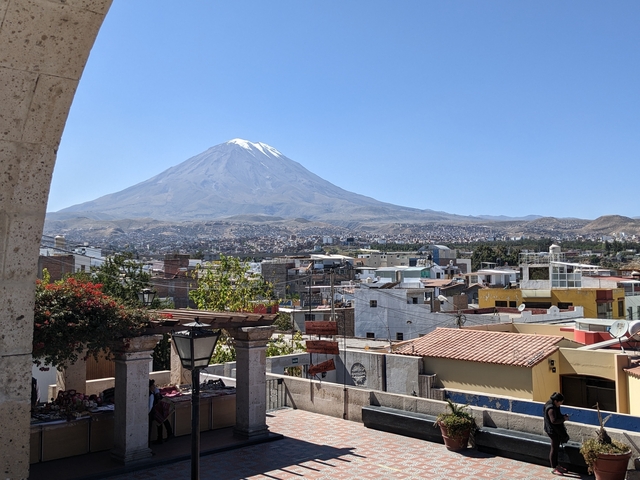       Cityscape with a prominent snow-capped mountain in the background.
  