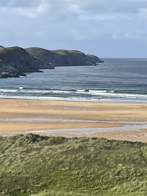       View of an empty beach with waves reaching the shore.
  