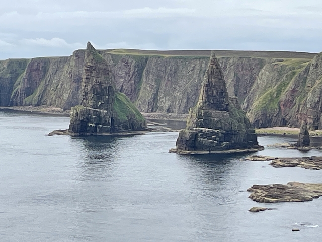 Dramatic coastal landscape with tall rock formations.