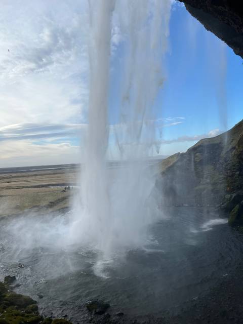 Waterfall cascading from a cliff into a misty pool.