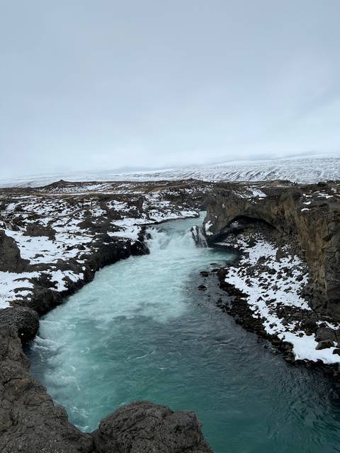       Waterfall cascading through a rocky landscape.
  