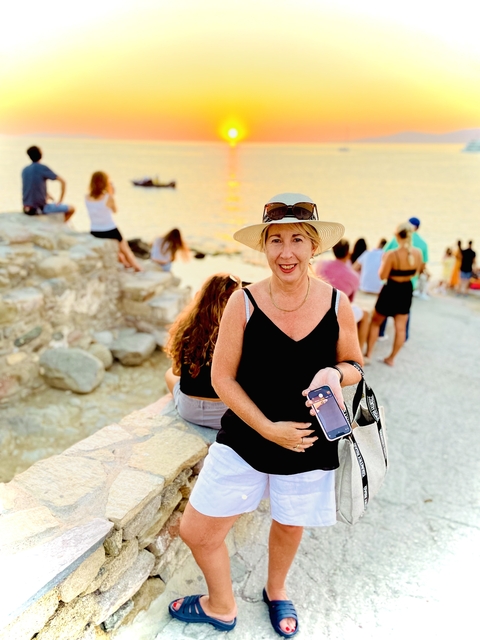 Woman posing at a viewpoint with a sunset.