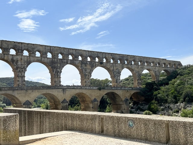       Ancient Roman aqueduct running through a countryside landscape.
  