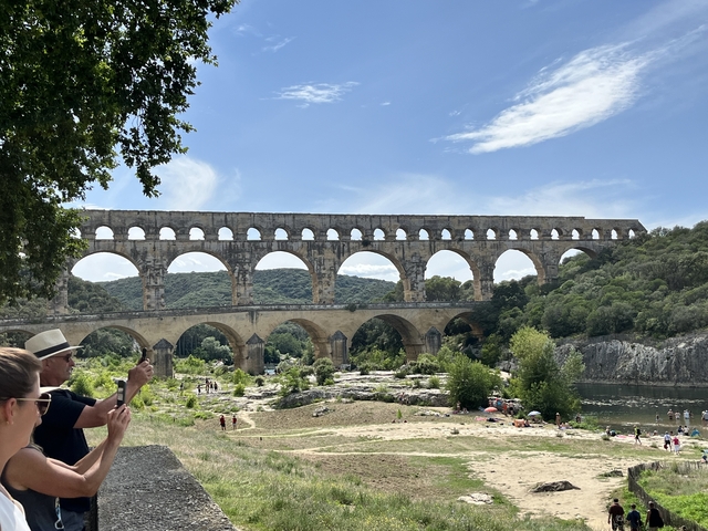       Pont du Gard, a Roman aqueduct in a natural setting with tourists.
  