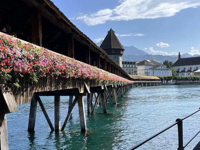       Close-up of a colorful historic wooden bridge with flowers.
  