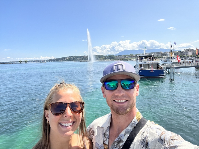       Couple posing in front of Lake Geneva with a fountain in the background.
  