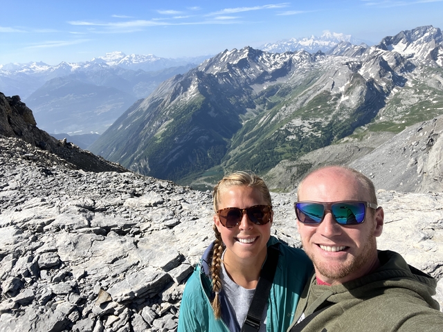       Couple taking a selfie on a rocky mountain edge.
  