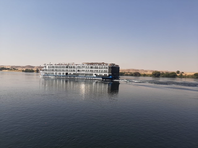       A cruise ship sailing on a river.
  