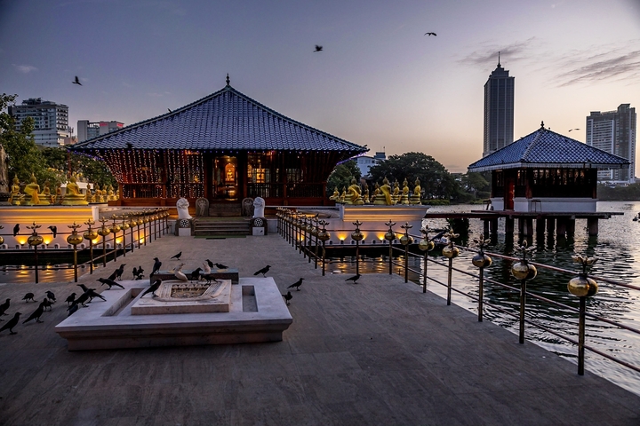       A beautiful temple by the water at sunset.
  