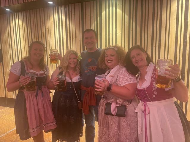 Group of people in traditional attire holding beverages.