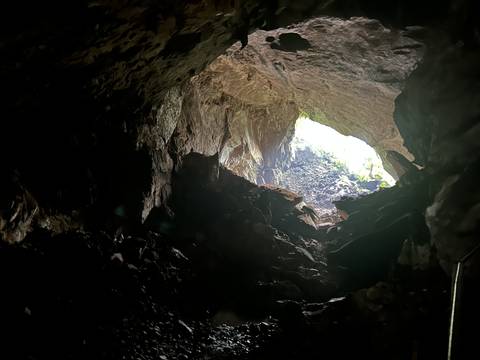       View from inside a cave looking outside into a bright area.
  
