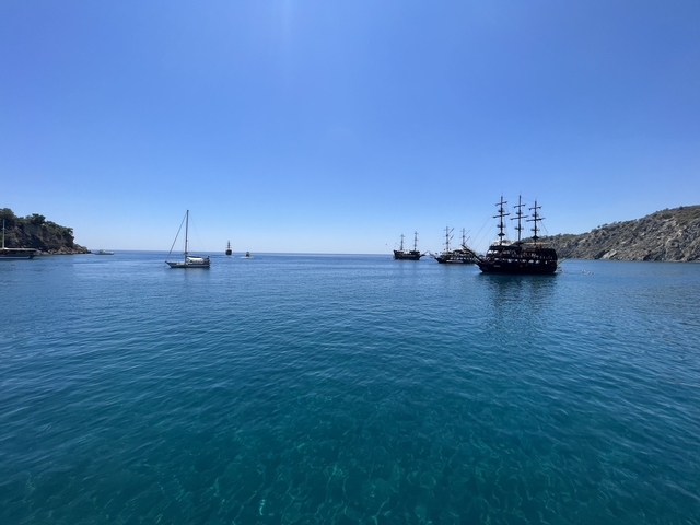       Harbor with sailboats and a pirate ship at sea.
  